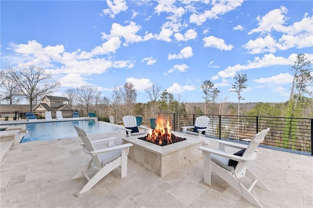 view of patio featuring an outdoor pool and a fire pit