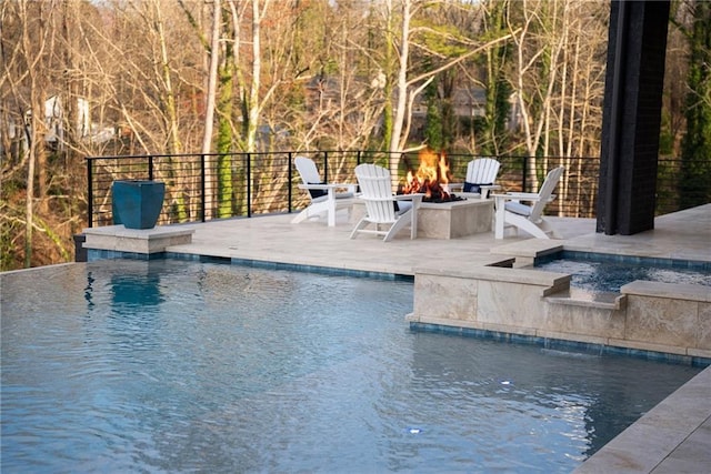 view of pool featuring an in ground hot tub, a patio area, a fenced in pool, and an outdoor fire pit