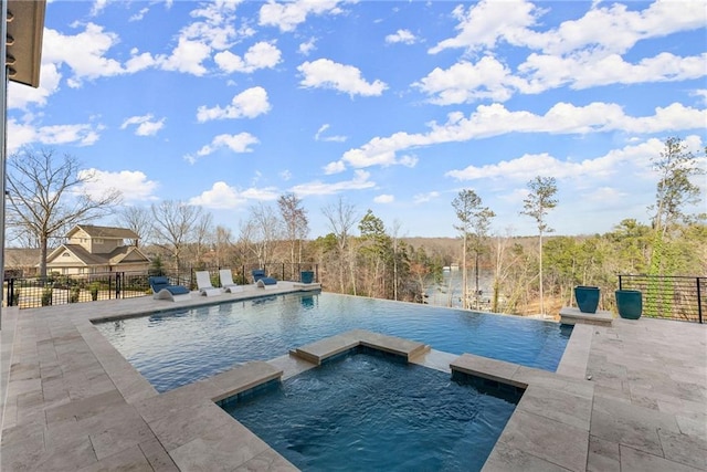 view of swimming pool featuring a patio area, a pool with connected hot tub, and fence