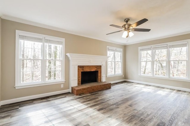 unfurnished living room with wood-type flooring, crown molding, ceiling fan, and a fireplace