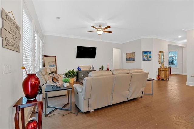 living room featuring hardwood / wood-style flooring, ceiling fan, and ornamental molding