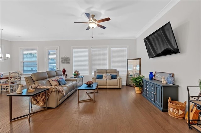 living room featuring crown molding, ceiling fan with notable chandelier, and light hardwood / wood-style floors