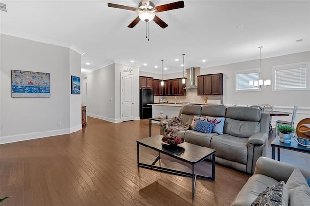 living room with crown molding, sink, dark hardwood / wood-style floors, and ceiling fan with notable chandelier