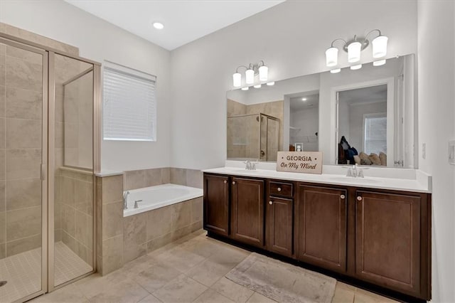 bathroom with tile patterned floors, vanity, and shower with separate bathtub