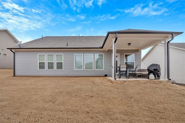 back of property with a lawn and a patio area