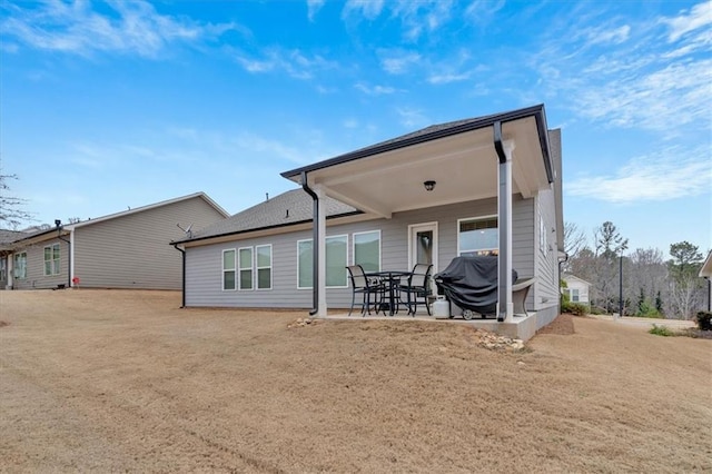 rear view of house featuring a yard and a patio