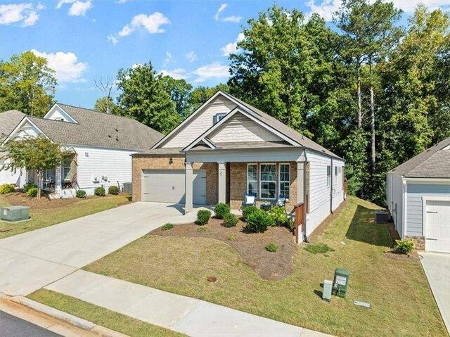 view of front of house with central AC, a porch, a garage, and a front lawn