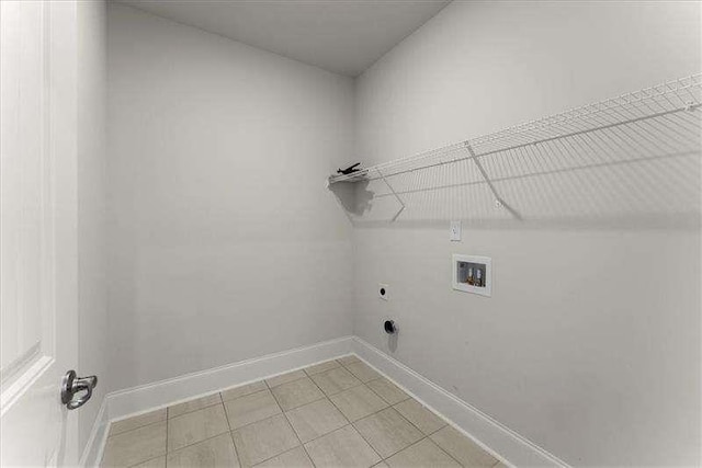 laundry area featuring light tile patterned floors, hookup for a washing machine, hookup for an electric dryer, laundry area, and baseboards