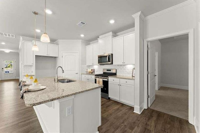 kitchen featuring stainless steel appliances, a sink, visible vents, white cabinets, and tasteful backsplash