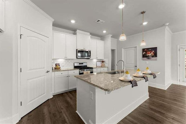 kitchen featuring light stone counters, dark wood-style flooring, visible vents, appliances with stainless steel finishes, and a sink