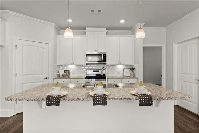 kitchen with a center island with sink, visible vents, appliances with stainless steel finishes, white cabinetry, and a sink