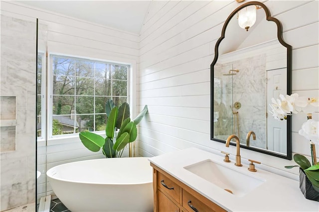 full bathroom with a freestanding tub, a shower stall, and vanity