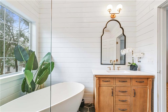 full bathroom featuring a soaking tub and vanity