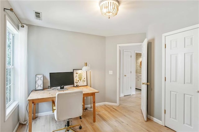 home office with visible vents, light wood-style flooring, and baseboards