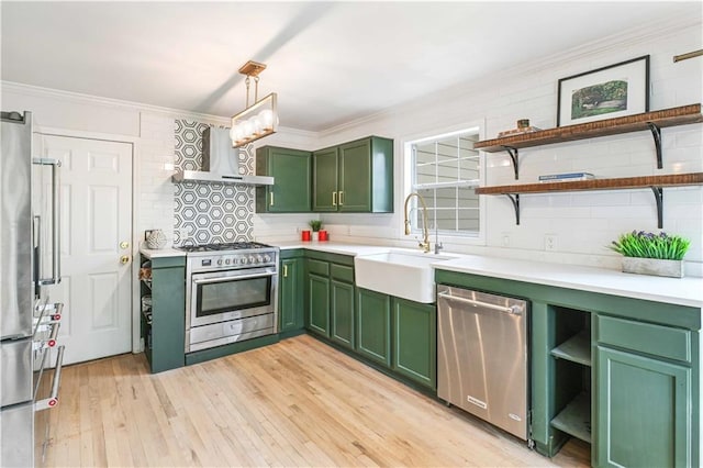 kitchen featuring open shelves, wall chimney exhaust hood, stainless steel appliances, and green cabinets