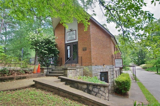 exterior space featuring stone siding and brick siding