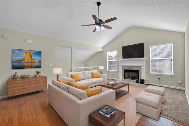 living room featuring a fireplace, a healthy amount of sunlight, and light hardwood / wood-style flooring