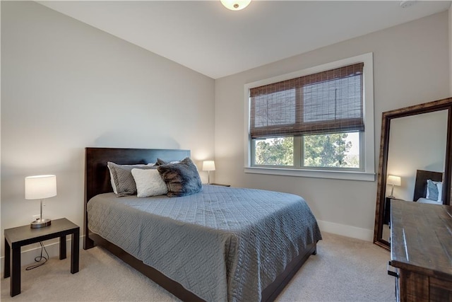 bedroom featuring lofted ceiling and light colored carpet