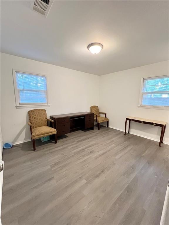 sitting room featuring baseboards, visible vents, and light wood finished floors