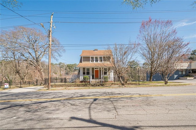 view of front of property with a fenced front yard and a porch