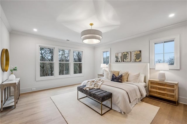 bedroom with crown molding and light hardwood / wood-style floors