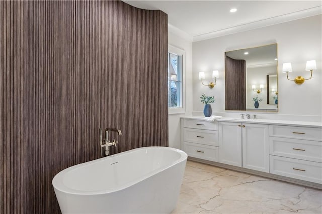 bathroom with crown molding, vanity, and a washtub