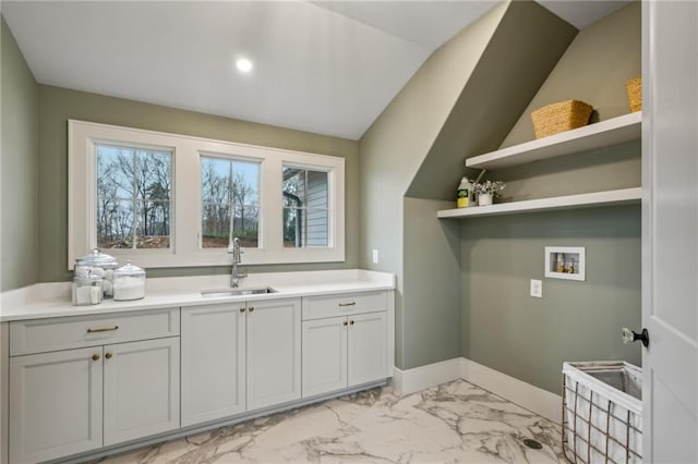 washroom with sink, hookup for a washing machine, and cabinets