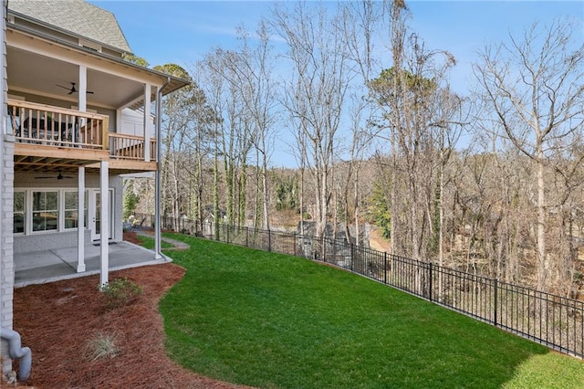 view of yard with ceiling fan, a balcony, and a patio area