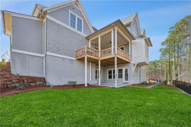 back of property with ceiling fan, a patio, a balcony, and a lawn