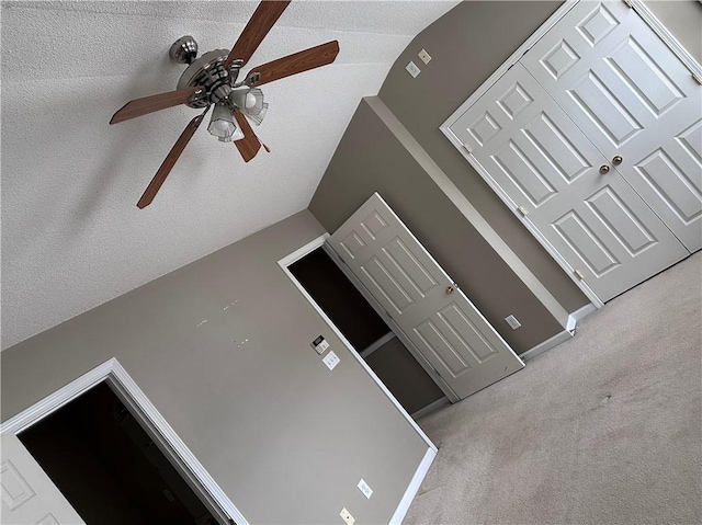 room details with a ceiling fan, carpet flooring, and a textured ceiling