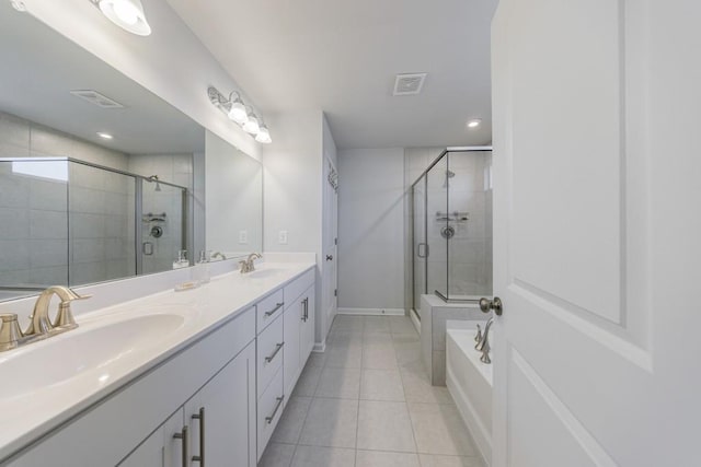 full bathroom featuring a stall shower, double vanity, a sink, and tile patterned floors