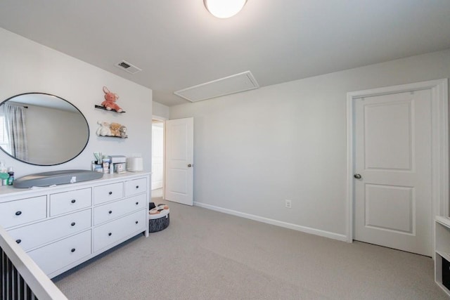 bedroom with attic access, light colored carpet, visible vents, and baseboards