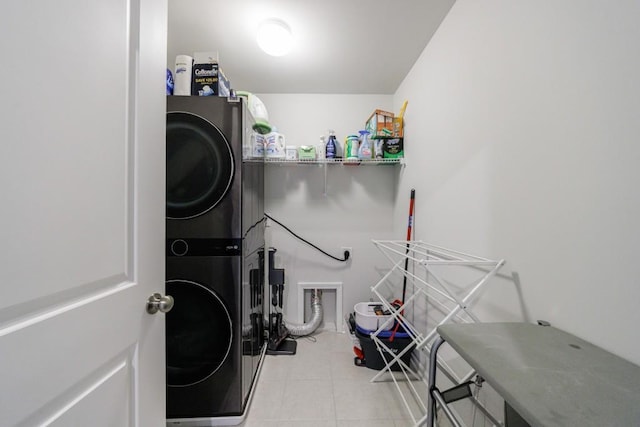 laundry room featuring stacked washing maching and dryer, tile patterned flooring, and laundry area