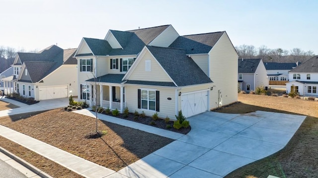 modern farmhouse featuring a residential view, covered porch, an attached garage, and concrete driveway