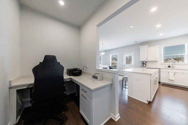 office space featuring recessed lighting, dark wood-style flooring, and a sink