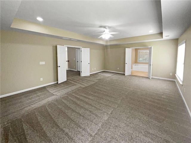 carpeted empty room featuring ceiling fan and a tray ceiling