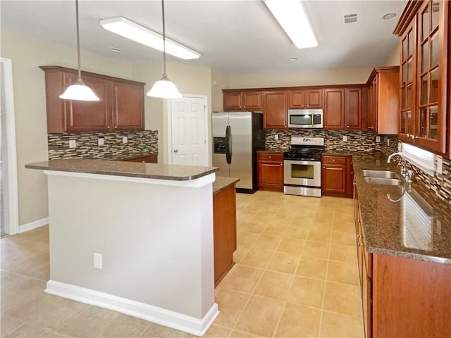 kitchen featuring stainless steel appliances, sink, kitchen peninsula, backsplash, and pendant lighting