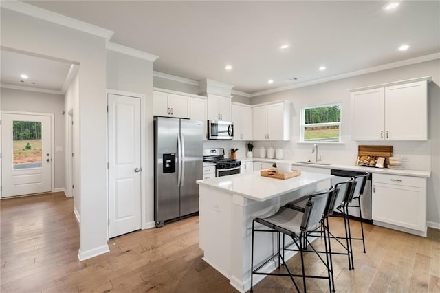 476 Village Ln, Fairburn, GA 30213 - kitchen with stainless steel appliances, ornamental molding, a kitchen bar, a center island, and white cabinetry