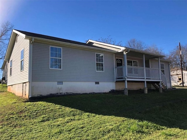 rear view of house featuring a lawn and a porch