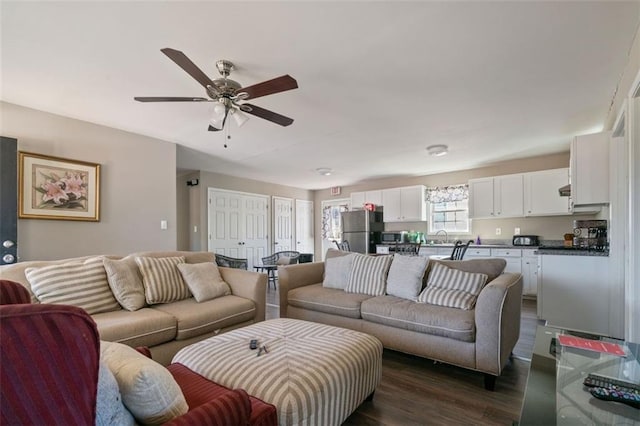 living room featuring ceiling fan, dark hardwood / wood-style floors, and sink