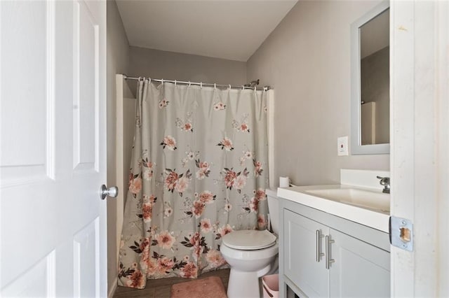 bathroom featuring toilet, a shower with shower curtain, and vanity