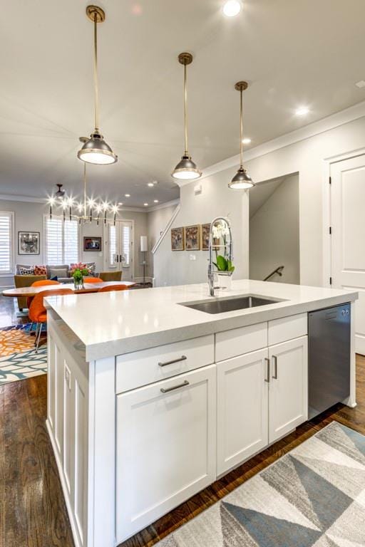 kitchen with dishwasher, a sink, open floor plan, crown molding, and plenty of natural light