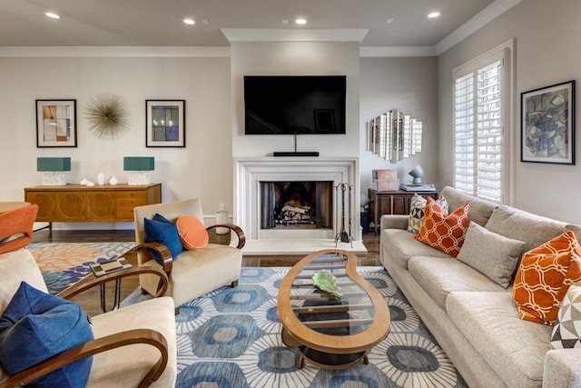 living area featuring wood finished floors, crown molding, a fireplace with raised hearth, and recessed lighting