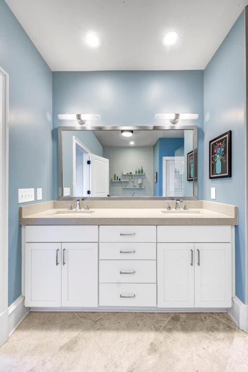 bathroom with double vanity and baseboards