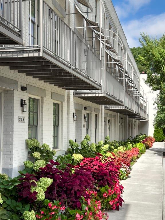 view of exterior entry with brick siding and a balcony