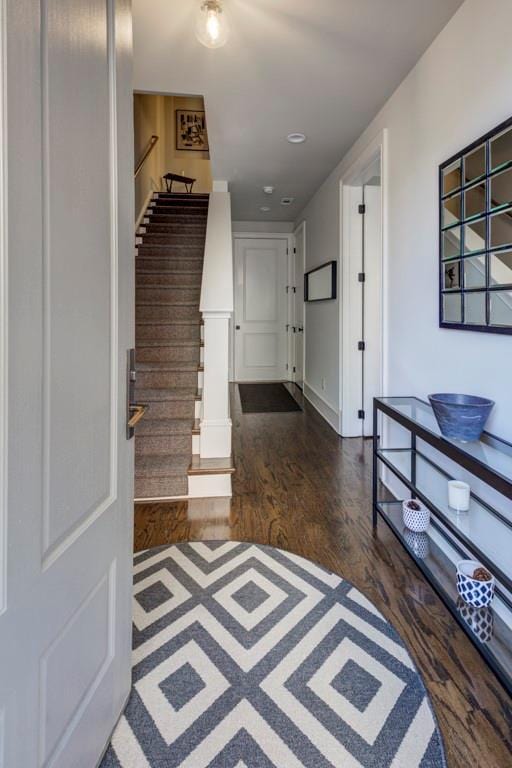 entryway with stairs, wood finished floors, and baseboards