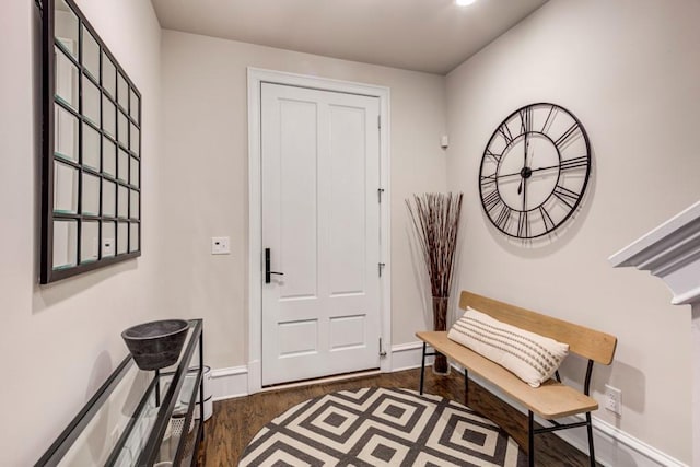 foyer entrance with dark wood finished floors and baseboards