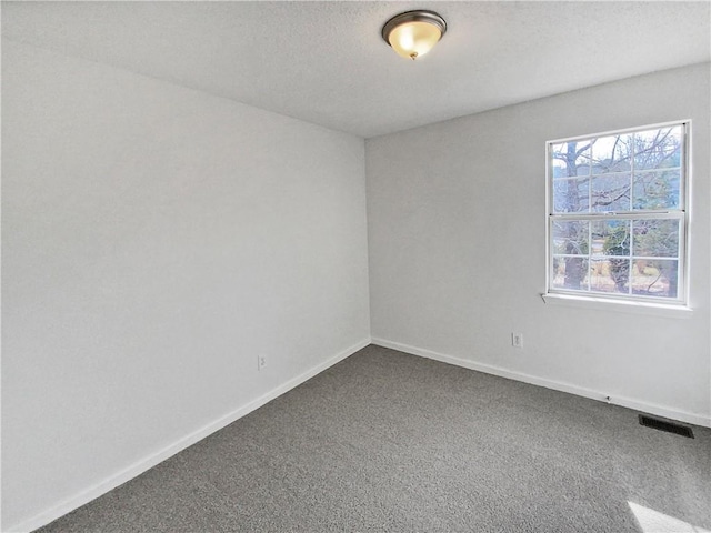 carpeted empty room featuring a textured ceiling