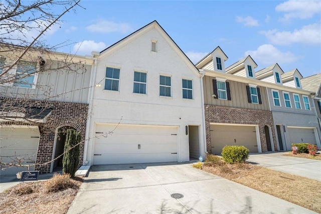 view of property featuring a garage, concrete driveway, and brick siding