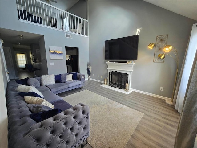 living room featuring high vaulted ceiling and hardwood / wood-style flooring